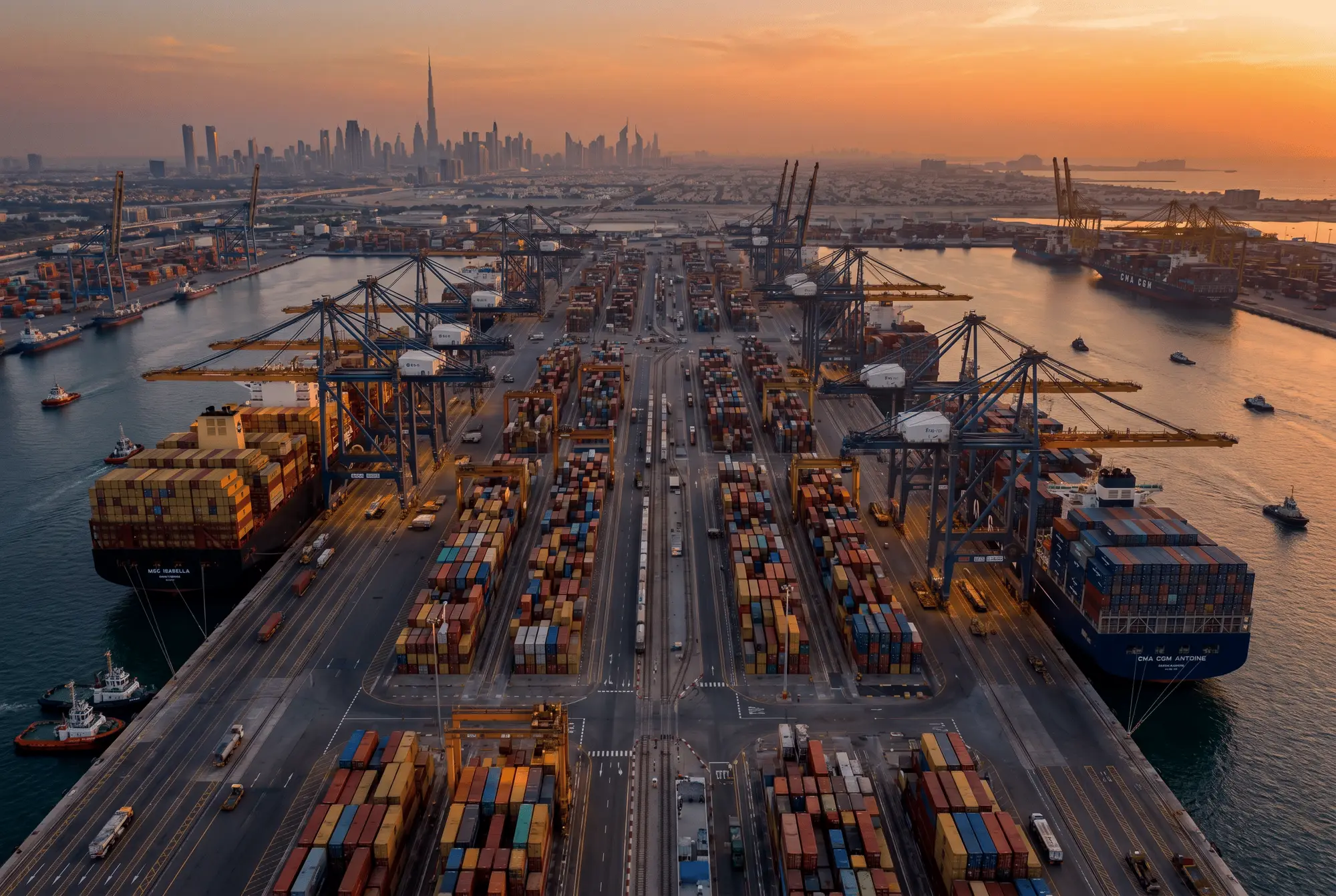 Commercial port at dusk with gantry cranes and container ships